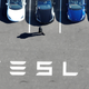 A man walks by a row of Tesla vehicles.
